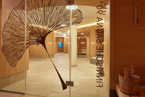 a room with a glass door with a large umbrella at Dorint Am Goethepark Weimar in Weimar