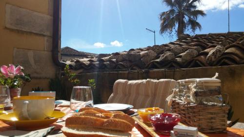 a table with a sandwich and a basket of bread at Risveglio Ibleo in Ragusa