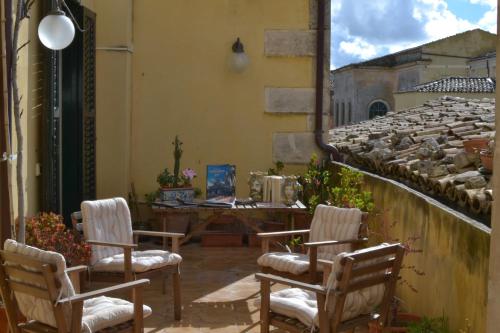 a patio with three chairs and a table on a building at Risveglio Ibleo in Ragusa