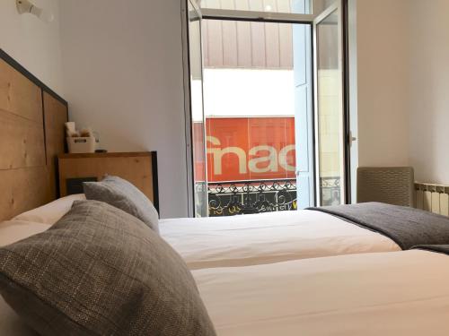 a bedroom with a bed and a large window at Pensión La Perla in Donostia-San Sebastián