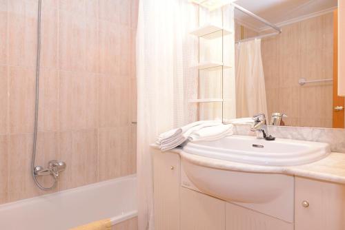 uma casa de banho branca com um lavatório e um chuveiro em Apartamentos La Terraza em Laredo