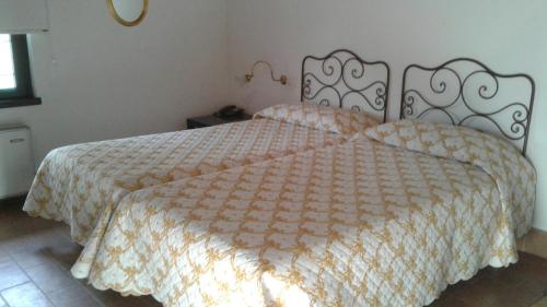 a bedroom with a large bed with a comforter at Agriturismo San Bruno in San Colombano al Lambro