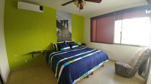 1 dormitorio con cama y pared verde en Casa Yikal, en Cancún