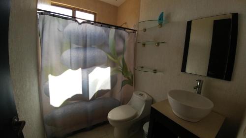 y baño con ducha, aseo y lavamanos.  en Casa Yikal, en Cancún