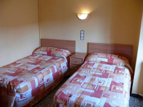 two beds sitting next to each other in a room at Hostal Rodes in Mequinenza