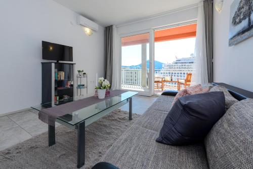 sala de estar con sofá y mesa de cristal en Lorelai Apartments en Dubrovnik