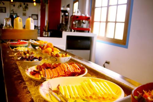 a buffet with plates of food on a counter at Hotel Villa Jazmin in Ica