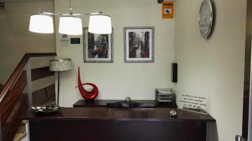 Habitación con escritorio y reloj en la pared en Pension Iruna en Santurce