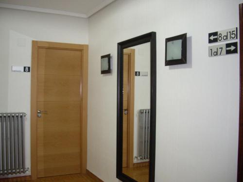 a mirror on a wall next to a door at Pension Iruna in Santurce
