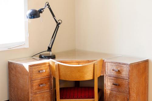 a desk with a chair and a lamp on top of it at Green Rooms in London