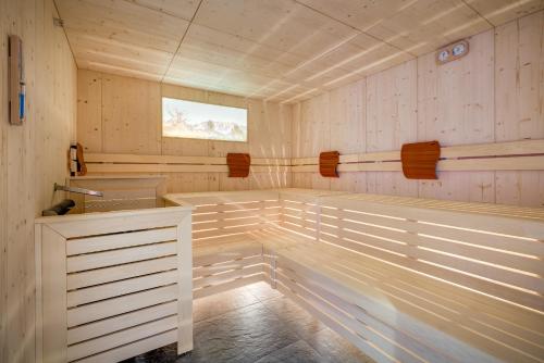 a sauna with white paneled walls and a window at Hotel Klostersepp in Chiusa