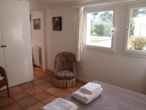 RognesにあるLa Tanganaのベッドルーム1室(ベッド1台、椅子、窓付)
