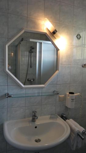 a bathroom with a sink and a mirror at Pension Dreiländerblick in Bad Gleichenberg