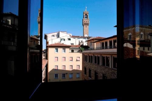 una vista da una finestra di una città con torre dell'orologio di Relais Cavalcanti Guest House a Firenze