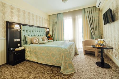 クルジュ・ナポカにあるHotel Stilのベッドと椅子付きのホテルルーム