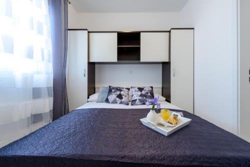 Un dormitorio con una cama con una bandeja de comida. en Lorelai Apartments en Dubrovnik