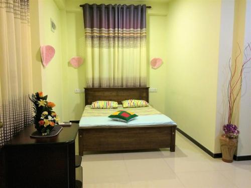 a bedroom with a bed with a window and a table at Romeo and Juliet Guest House in Negombo