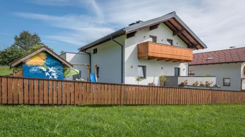 a house with a wooden fence in front of it at Haus Mösenlechner in Maishofen