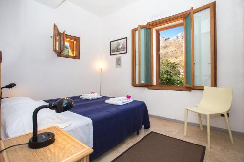 サン・ヴィート・ロ・カーポにあるVilla Firriatoのベッド、窓、椅子が備わる客室です。