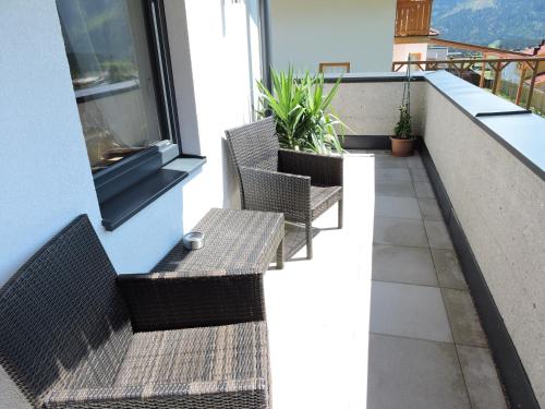 a balcony with two chairs and a window at Haus Mösenlechner in Maishofen