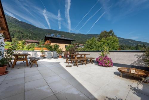 a patio with tables and benches on a roof at Haus Mösenlechner in Maishofen