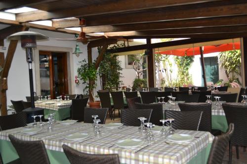Trulli Aia Piccola في ألبيروبيلو: غرفة طعام مع طاولات وكراسي وطاولة
