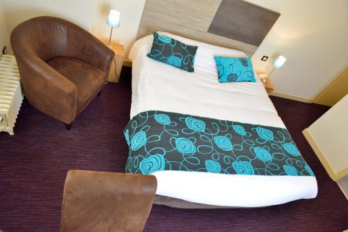 a hotel room with a bed and a chair at Logis Hostellerie de l'Abbaye in Celles-sur-Belle