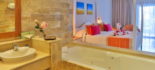 a bathroom with a bed and a tub and a sink at Cofresi Palm Beach & Spa Resort - All Inclusive in San Felipe de Puerto Plata