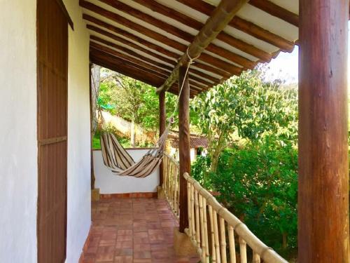 a porch with a hammock on a house at Achiotte by Masaya Collection in Barichara