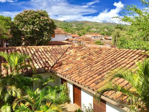 a house with a tile roof with palm trees at Achiotte by Masaya Collection in Barichara