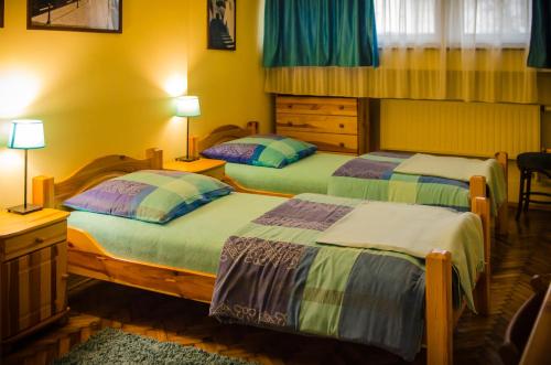 een slaapkamer met 2 bedden en een bureau met 2 lampen bij Indalo Rooms in Krakau