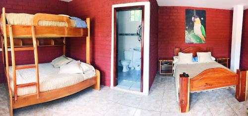 a bedroom with two bunk beds and a mirror at Hosteria Don Elias in Puyo