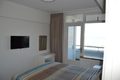 - une chambre avec un lit et une vue sur l'océan dans l'établissement Beach Apartment Ikusasa, à Zandvoort