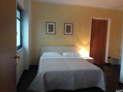 a bedroom with a bed with a white bedspread at Affittacamere arabafenice in Vezzano Ligure