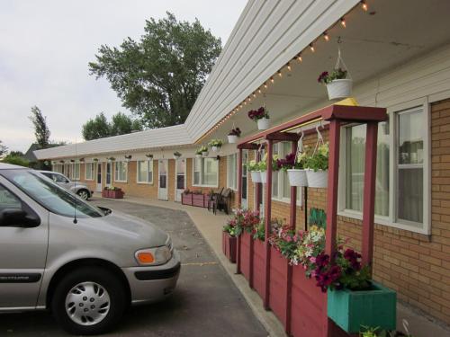 a car parked in front of a building with flowers at City Centre Motel in Swift Current