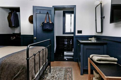 a bedroom with a bed and a sink and a mirror at Anvil Hotel in Jackson