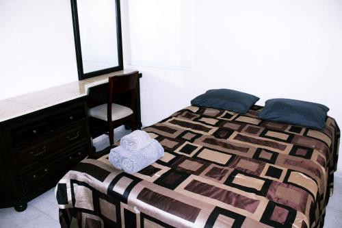 a bedroom with a bed with a desk and a chair at Casita Aurora in Chemuyil