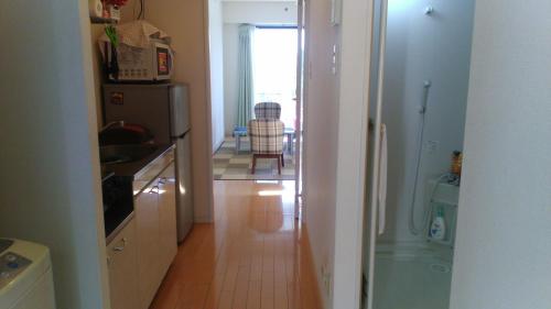 a kitchen with a refrigerator and a table with a chair at Gracias in Kagoshima