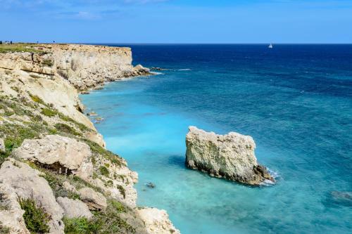 a large rock in the middle of the ocean at Zenzero e Limone in Siracusa