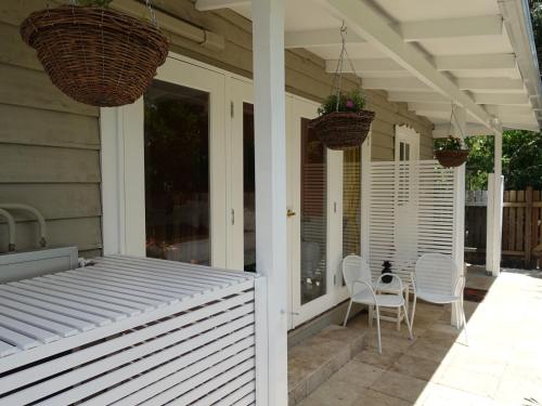 a porch with chairs and a table on a house at Winston Cottage in Palmwoods