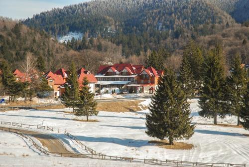 a resort in the mountains with snow and trees at Monterai Resort in Poiana Brasov