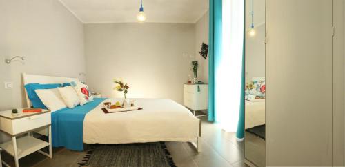 a bedroom with a blue and white bed and a mirror at BnB Anacleto in Bassacutena