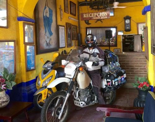 a man sitting on a motorcycle in front of a shop at Pension California in La Paz