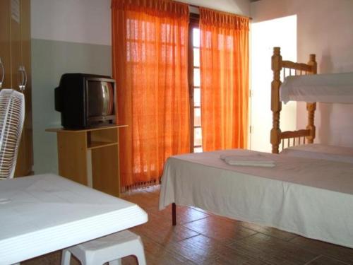 a bedroom with two bunk beds and a tv at Oriental Hotel in Sorocaba