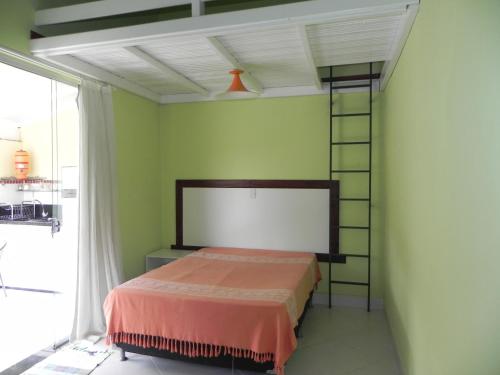 a bedroom with a bed in a room with green walls at Jardim dos Sonhos in Santo Antônio do Leite
