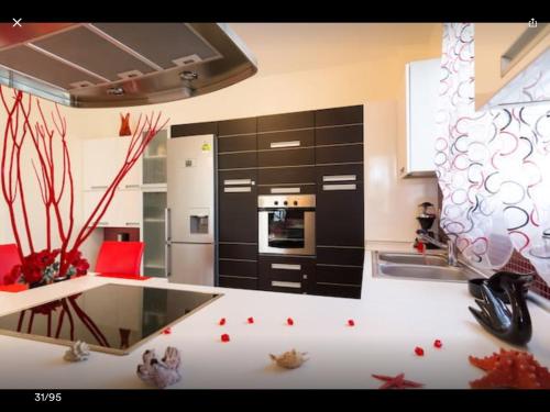 a kitchen with black cabinets and a counter with red chairs at Artisti Elena in Paralia Katerinis
