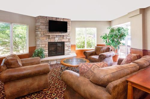 a living room with leather furniture and a fireplace at Super 8 by Wyndham Traverse City in Traverse City