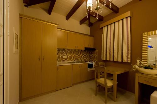 a kitchen with wooden cabinets and a table with a chair at Ideal House in Parga
