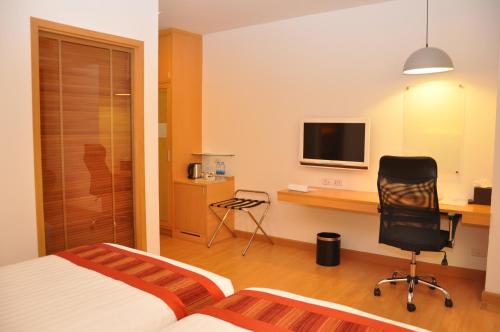 a bedroom with a desk and a bed and a chair at Iyarin @ Tuk Chang Hotel in Bangkok