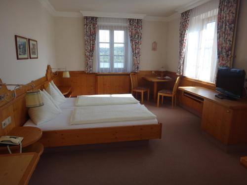 1 dormitorio con 1 cama grande, mesa y sillas en Donau-Rad-Hotel Wachauerhof en Marbach an der Donau